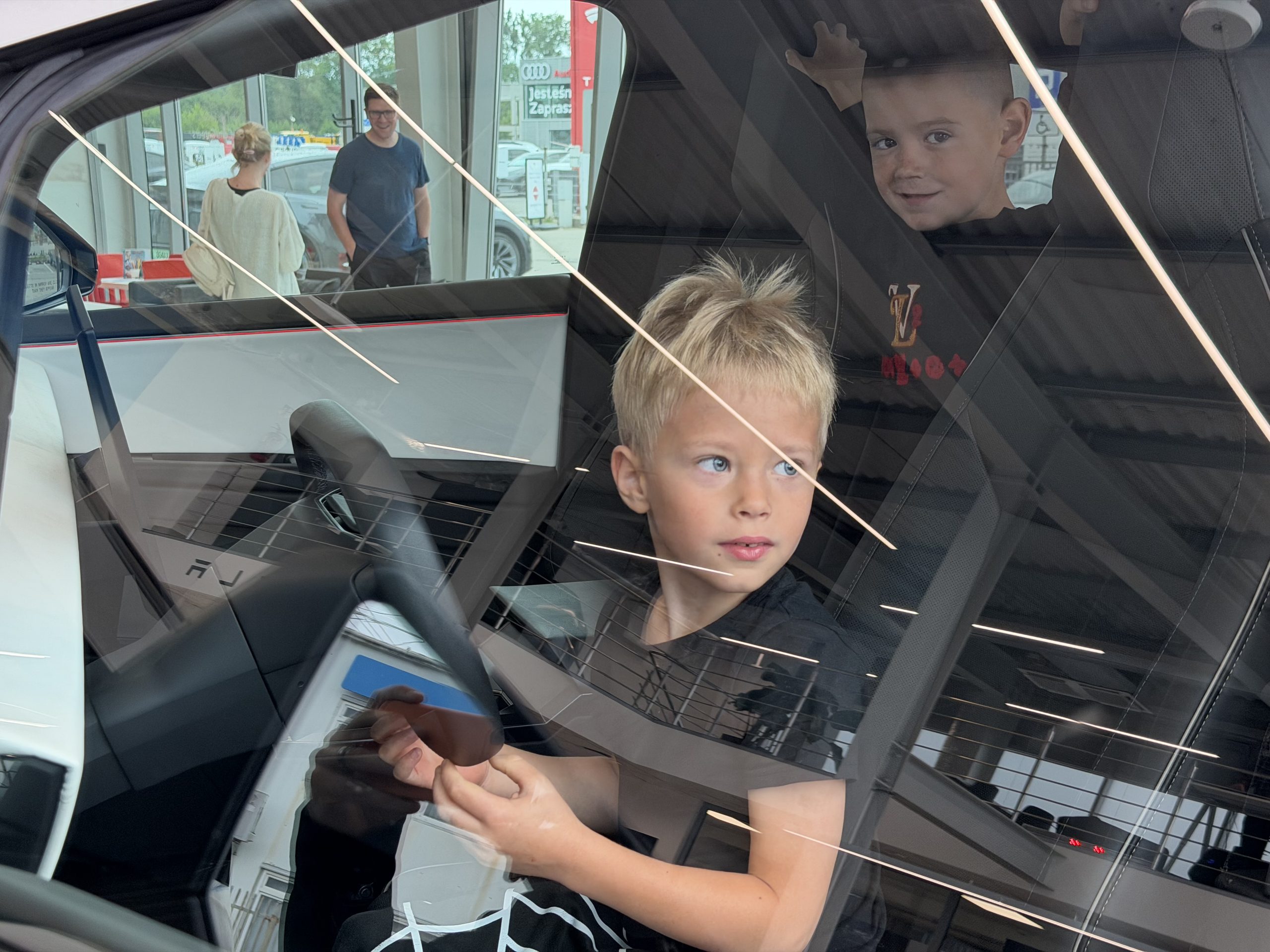 Dzieci we wnętrzu Cybertrucka Cyberbeast – jedno za kierownicą, drugie na tylnym siedzeniu
